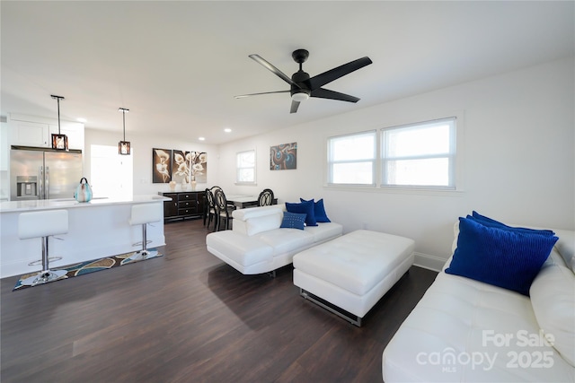 living room featuring ceiling fan and dark hardwood / wood-style floors