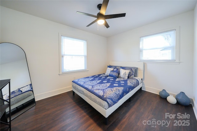 bedroom featuring multiple windows, dark hardwood / wood-style floors, and ceiling fan