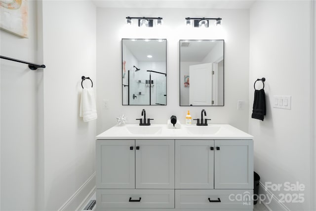 bathroom featuring a shower with shower door and vanity