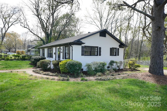 view of side of home with a yard