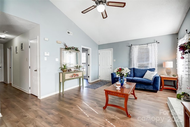 living room featuring ceiling fan, wood-type flooring, and high vaulted ceiling