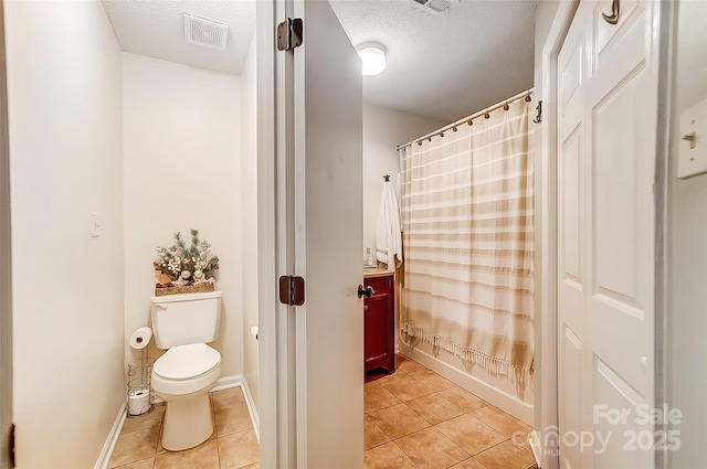 bathroom featuring a textured ceiling, tile patterned floors, shower / bathtub combination with curtain, and toilet