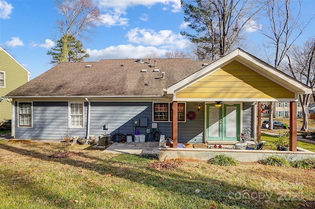 rear view of property featuring ceiling fan, a patio area, and a lawn