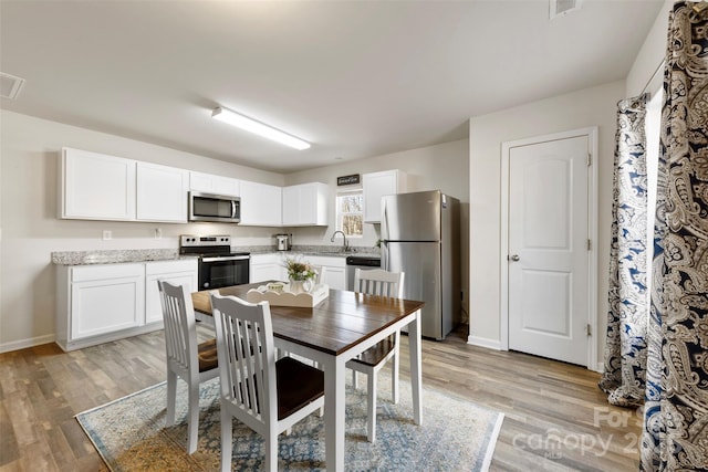 dining space featuring sink and light hardwood / wood-style floors