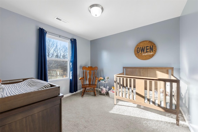 bedroom featuring a nursery area and carpet