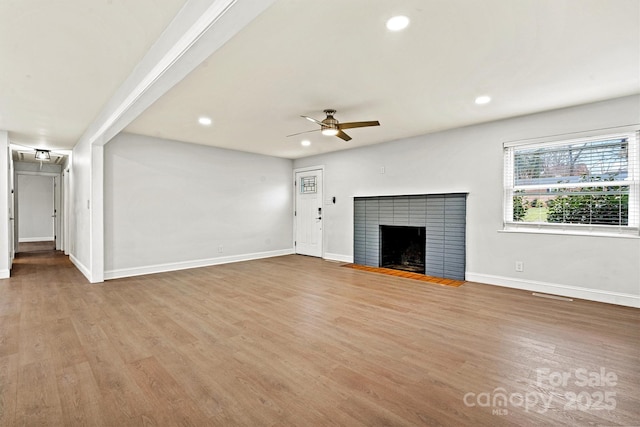 unfurnished living room featuring hardwood / wood-style floors, a fireplace, and ceiling fan