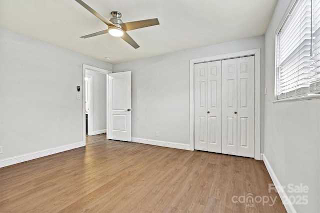 unfurnished bedroom with ceiling fan, light wood-type flooring, and a closet