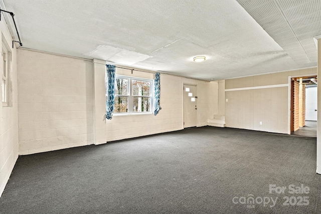 carpeted empty room featuring a textured ceiling