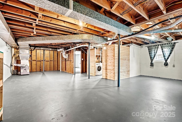 basement featuring washer / dryer and heating unit