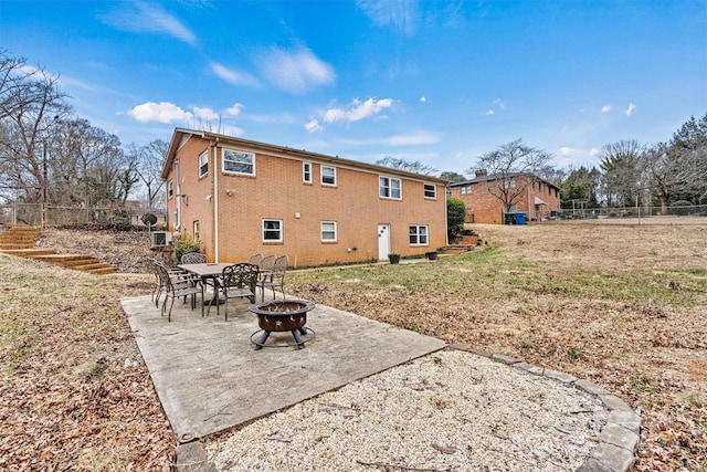 back of property featuring a patio, a yard, and a fire pit