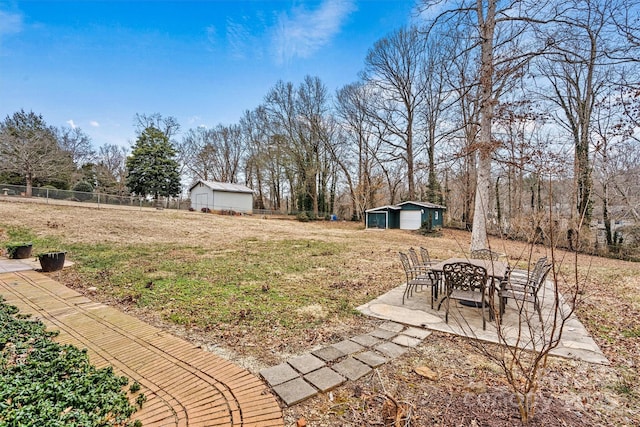 view of yard with a garage, an outdoor structure, and a patio area