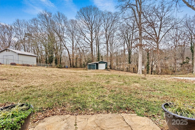 view of yard featuring a garage and an outbuilding