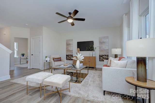 living room featuring ceiling fan and light hardwood / wood-style flooring