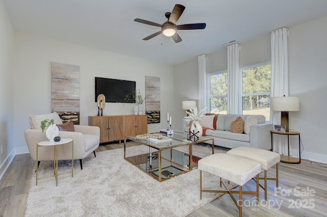 living room with light wood-type flooring and ceiling fan