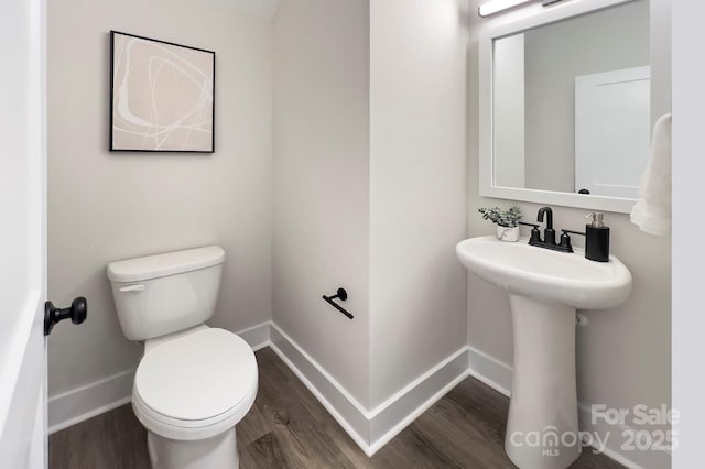 bathroom featuring sink, toilet, and wood-type flooring