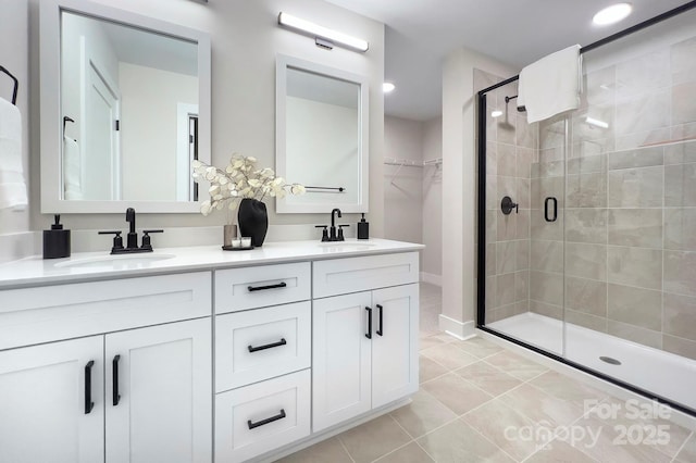 bathroom with a shower with door, vanity, and tile patterned flooring