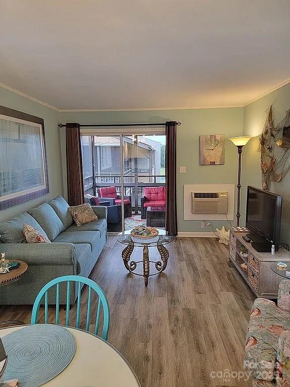 living room with a wall mounted AC and hardwood / wood-style flooring