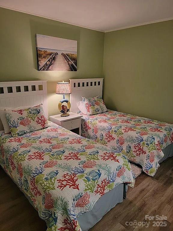 bedroom featuring ornamental molding and hardwood / wood-style floors