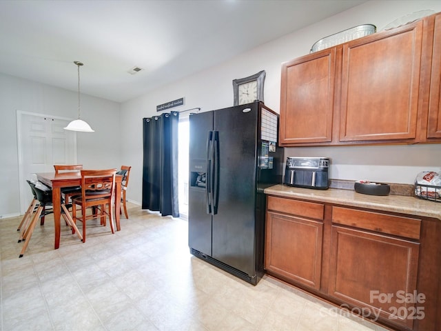 kitchen with black fridge and pendant lighting