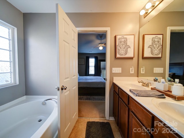 bathroom with ceiling fan, vanity, a bathtub, and tile patterned floors