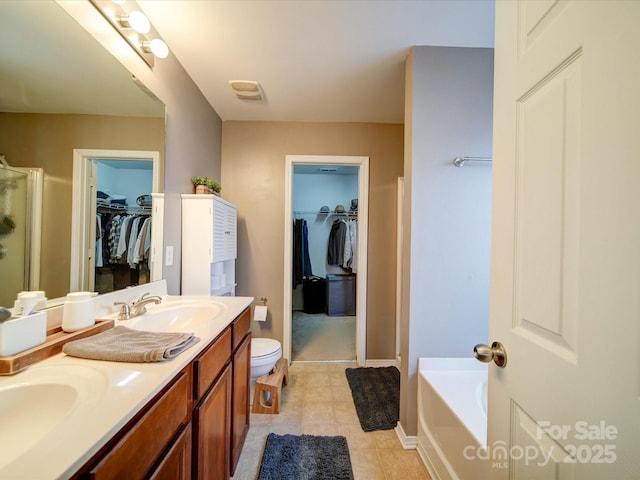 bathroom with toilet, vanity, tile patterned floors, and a bathing tub