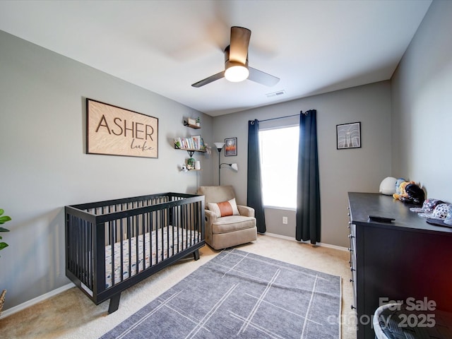 bedroom featuring ceiling fan, carpet flooring, and a nursery area