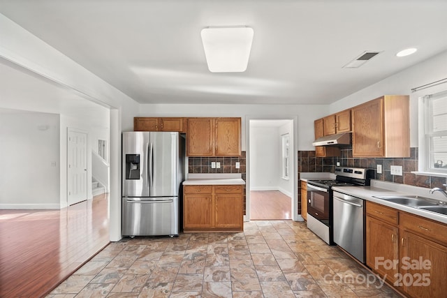 kitchen featuring stainless steel appliances, tasteful backsplash, and sink