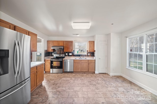 kitchen featuring stainless steel appliances, decorative backsplash, and sink