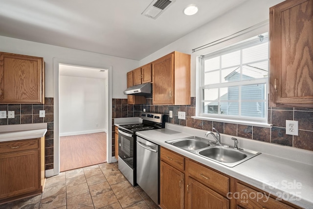 kitchen with sink, backsplash, and appliances with stainless steel finishes