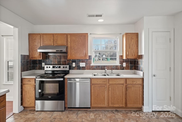 kitchen featuring stainless steel appliances, backsplash, and sink