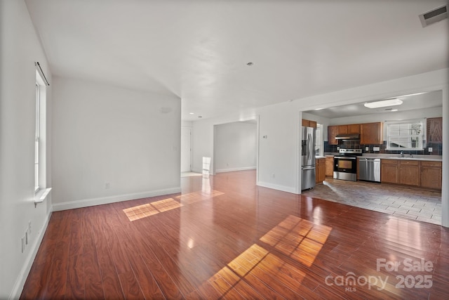 unfurnished living room with sink and hardwood / wood-style floors