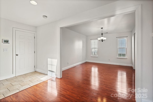 empty room featuring light hardwood / wood-style flooring and an inviting chandelier