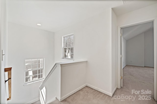 corridor featuring a wealth of natural light and light carpet