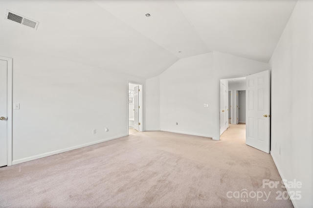 carpeted empty room featuring lofted ceiling