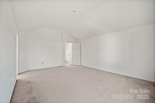 interior space with light carpet and vaulted ceiling