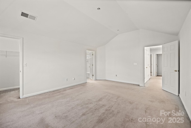 interior space featuring lofted ceiling and light carpet