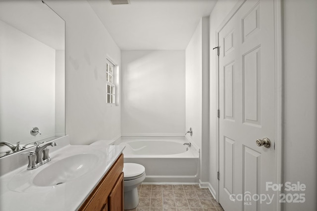 bathroom featuring a bathing tub, vanity, and toilet