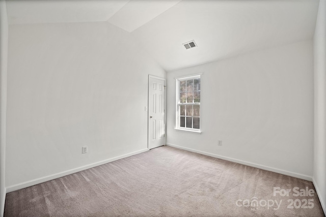 unfurnished room featuring light carpet and vaulted ceiling