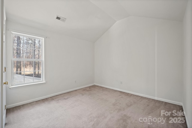 carpeted empty room featuring lofted ceiling