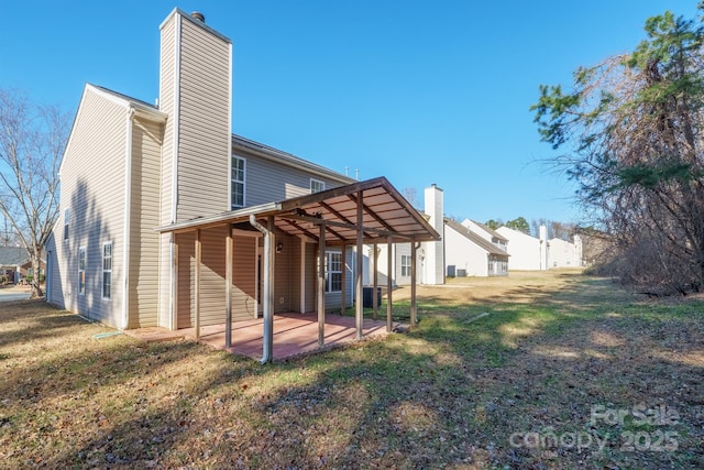 back of property with a yard and a patio area