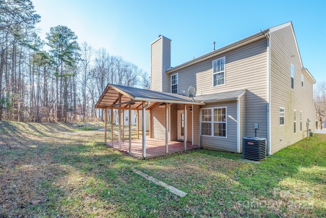 rear view of property with a patio, central air condition unit, and a yard