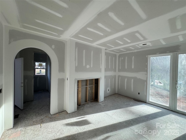 spare room featuring arched walkways