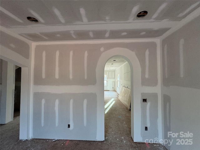 unfurnished room featuring arched walkways