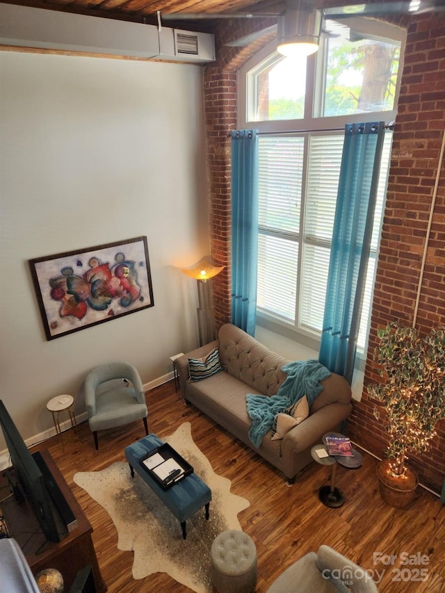 living room featuring brick wall and hardwood / wood-style flooring