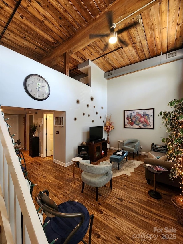 living room with a high ceiling, wood ceiling, hardwood / wood-style floors, ceiling fan, and beamed ceiling