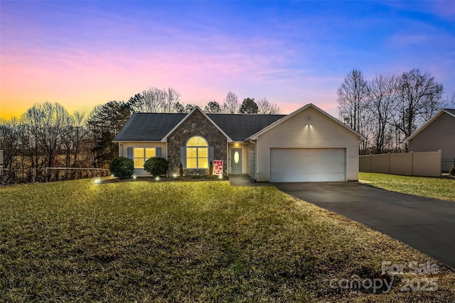 ranch-style home with a garage and a yard