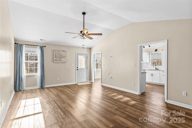 spare room featuring hardwood / wood-style flooring, vaulted ceiling, sink, and ceiling fan