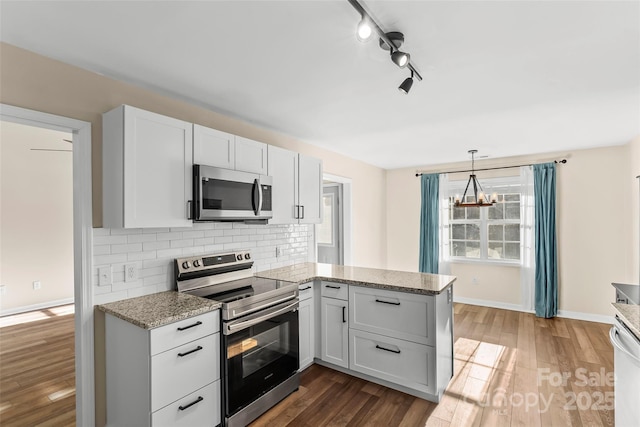 kitchen with backsplash, stainless steel appliances, dark hardwood / wood-style floors, and white cabinets