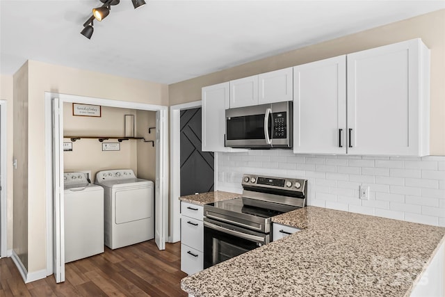 kitchen with light stone counters, white cabinetry, appliances with stainless steel finishes, independent washer and dryer, and decorative backsplash