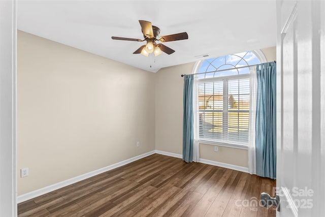 empty room with dark hardwood / wood-style floors and ceiling fan